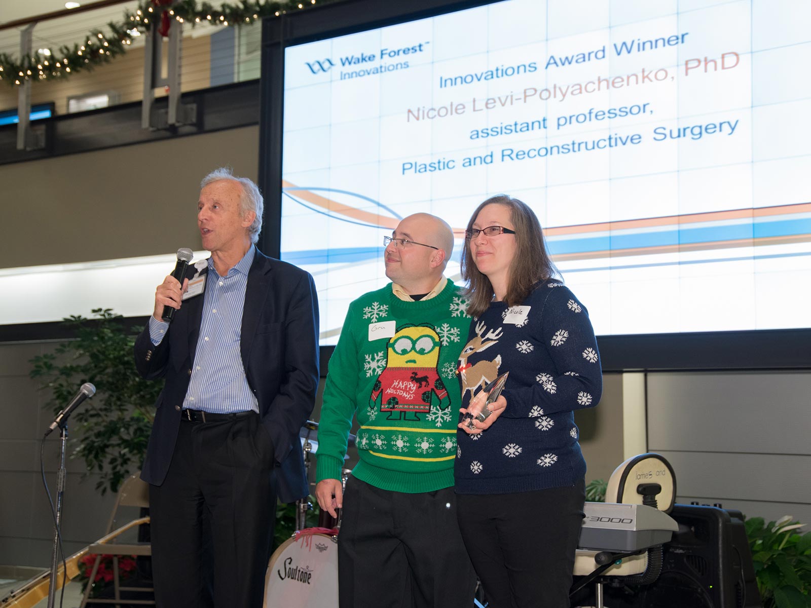 Nicole Levi-Polyachenko, pictured with her husband, Alex Polyachenko, received the Innovation Award from Eric Tomlinson (while proudly sporting the ugly sweater theme of the night's event)